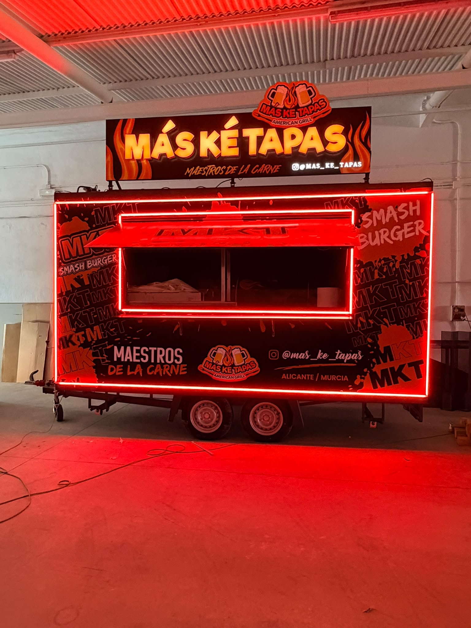 Vista frontal de la foodtruck MÁS KE TAPAS con ventanilla de servicio y grafismos MKT Smash Burger
