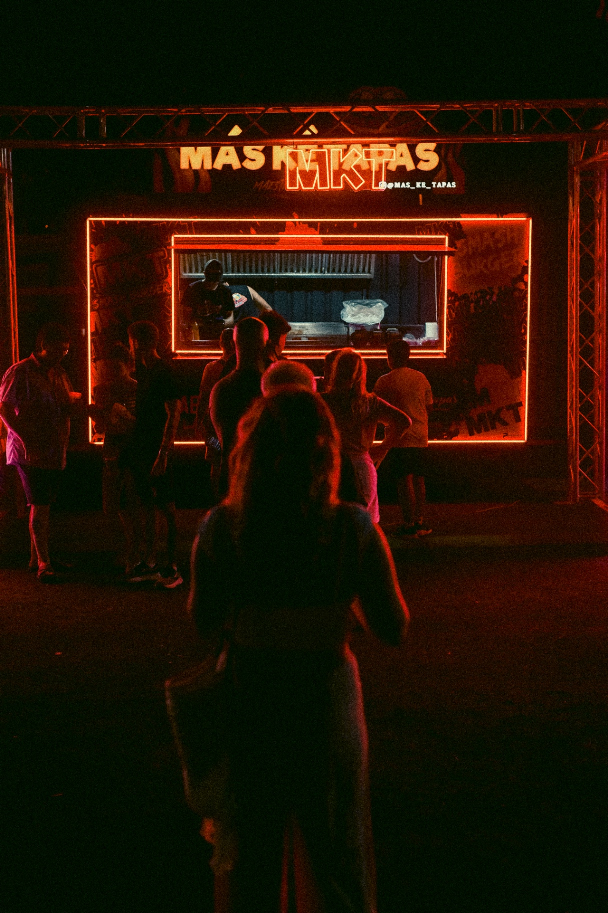 Vista nocturna de la foodtruck MKT con clientes esperando su pedido